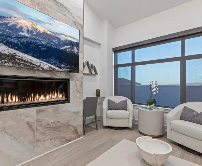 photo of a living room with a fire place and some sofa chairs
